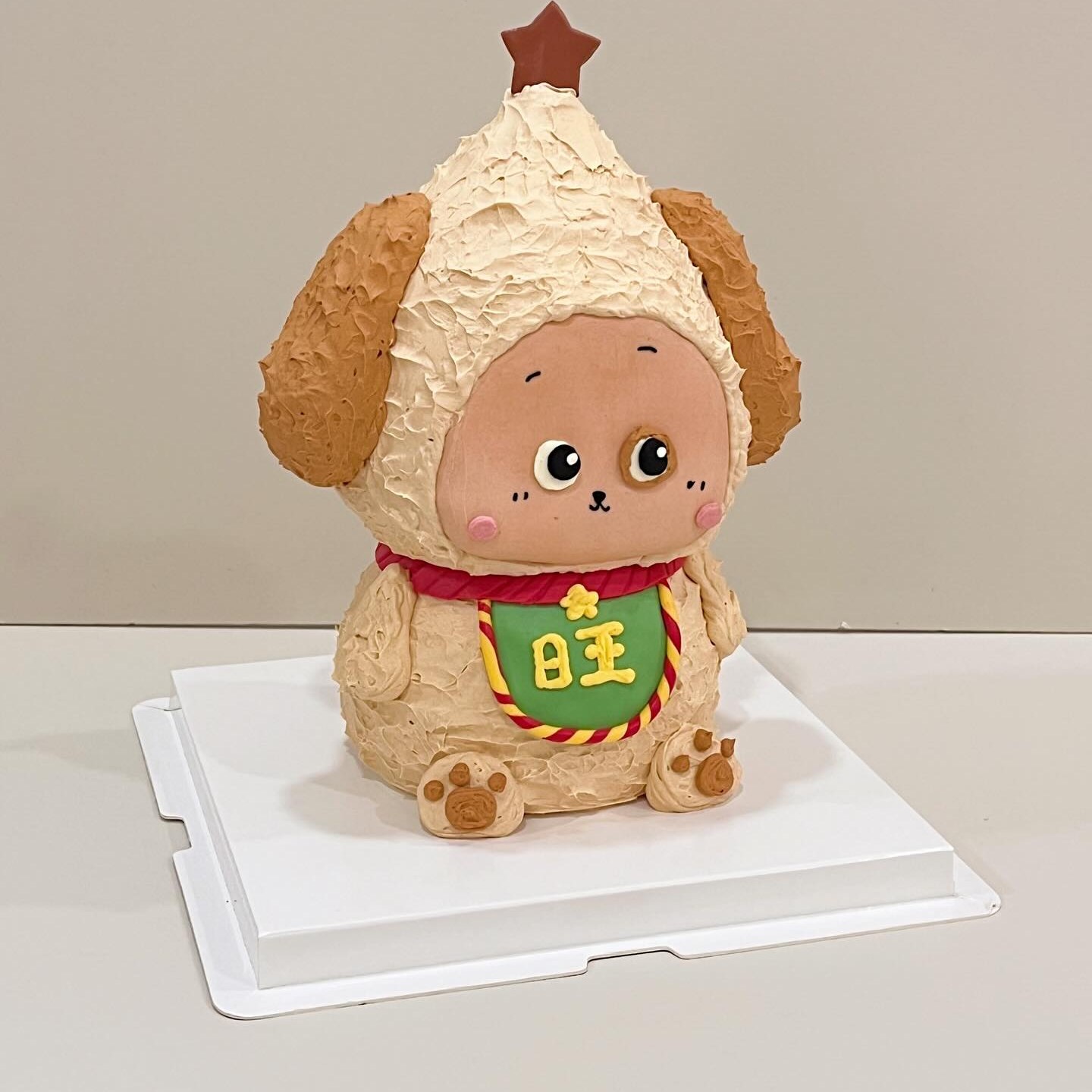 Puppy-eared character cake with a lucky red badge and star topper
