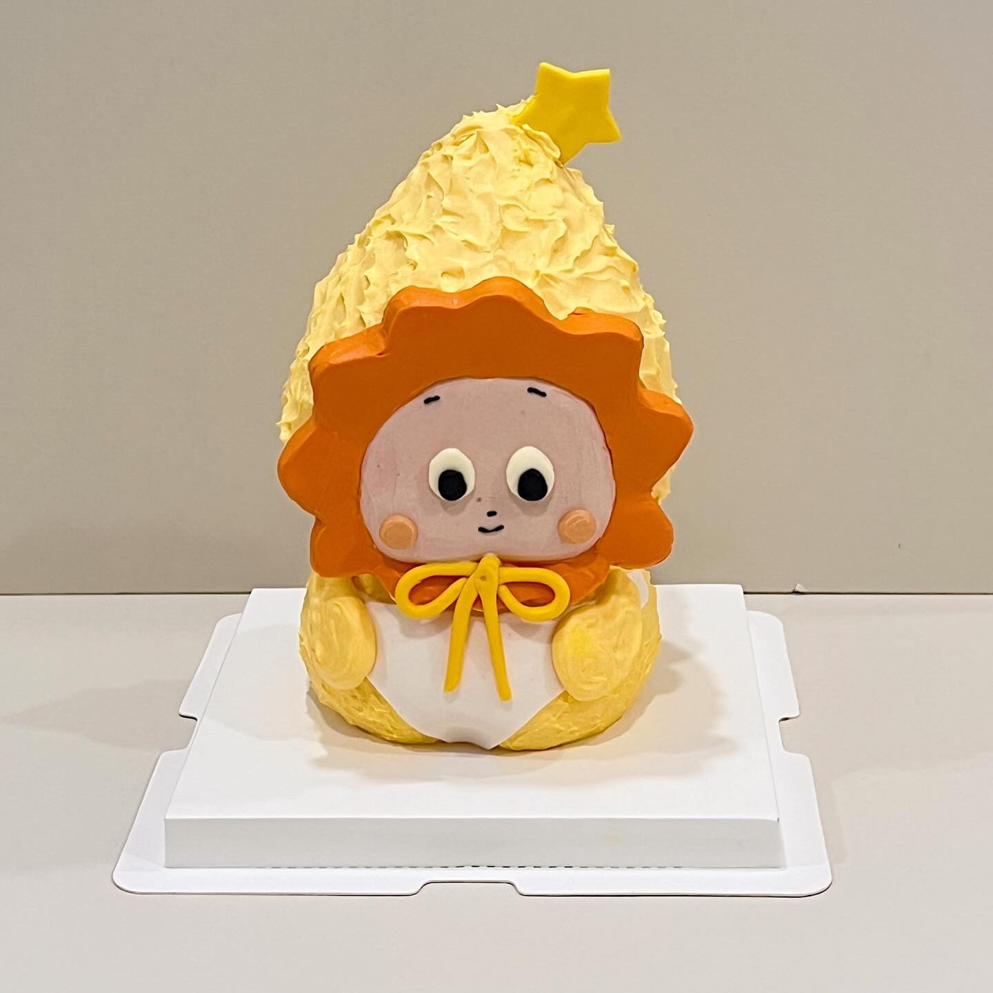 Orange lion-maned character cake with a star topper
