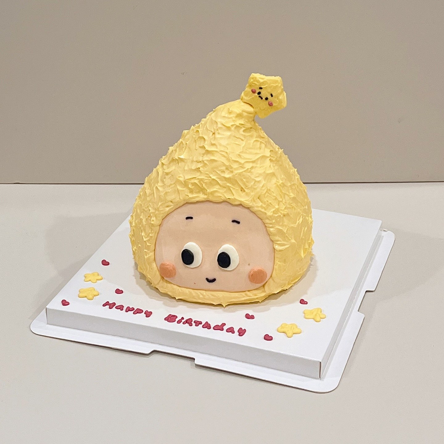 Star-topped character cake with a Happy Birthday message on the board