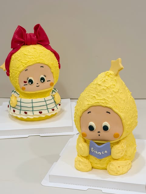 Two yellow character cakes with hand-piped buttercream fur and a star topper
