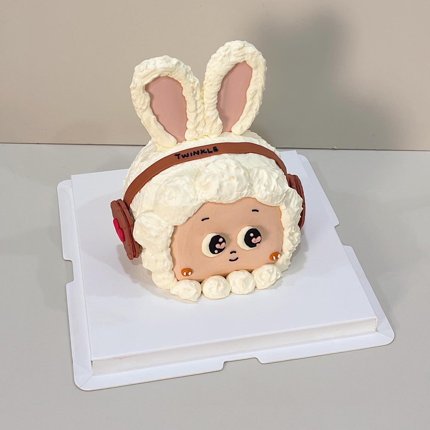 Bunny-eared character cake with headphones and a ribbon headband