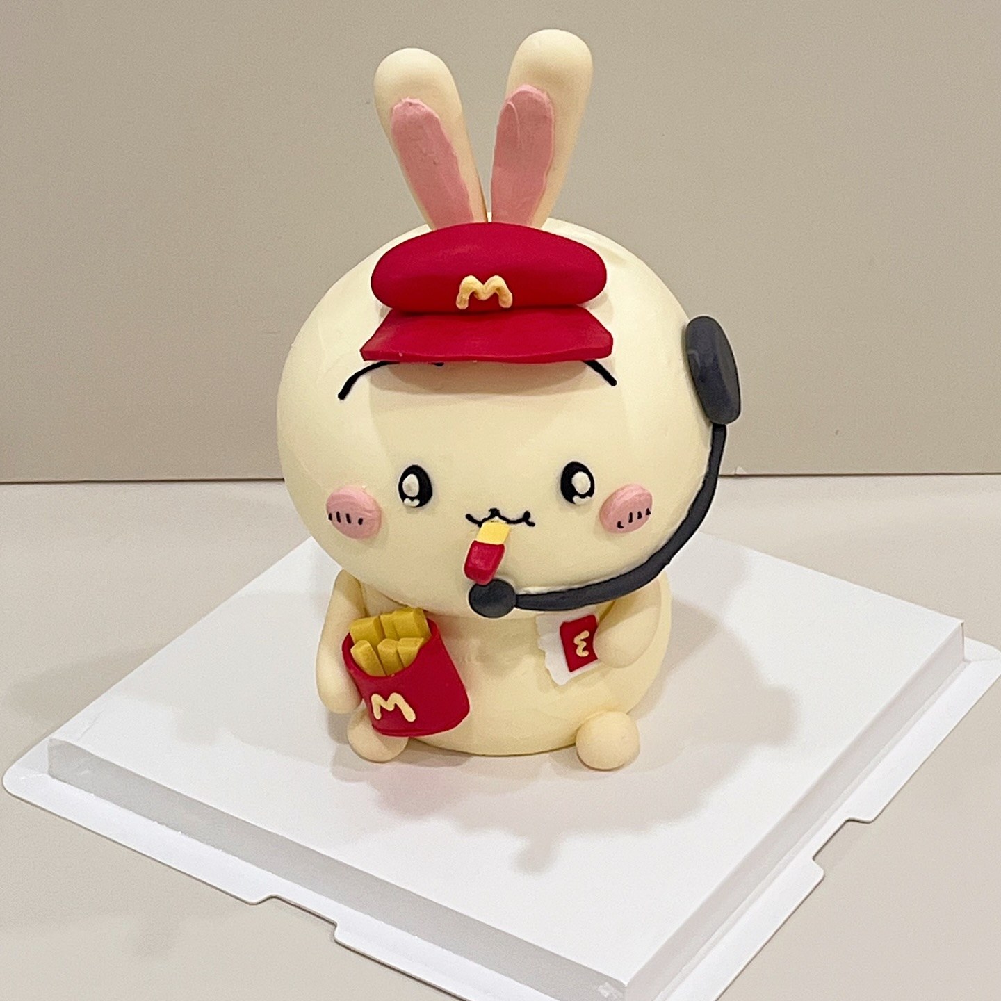 Rabbit character cake wearing a red branded cap and holding a fries box