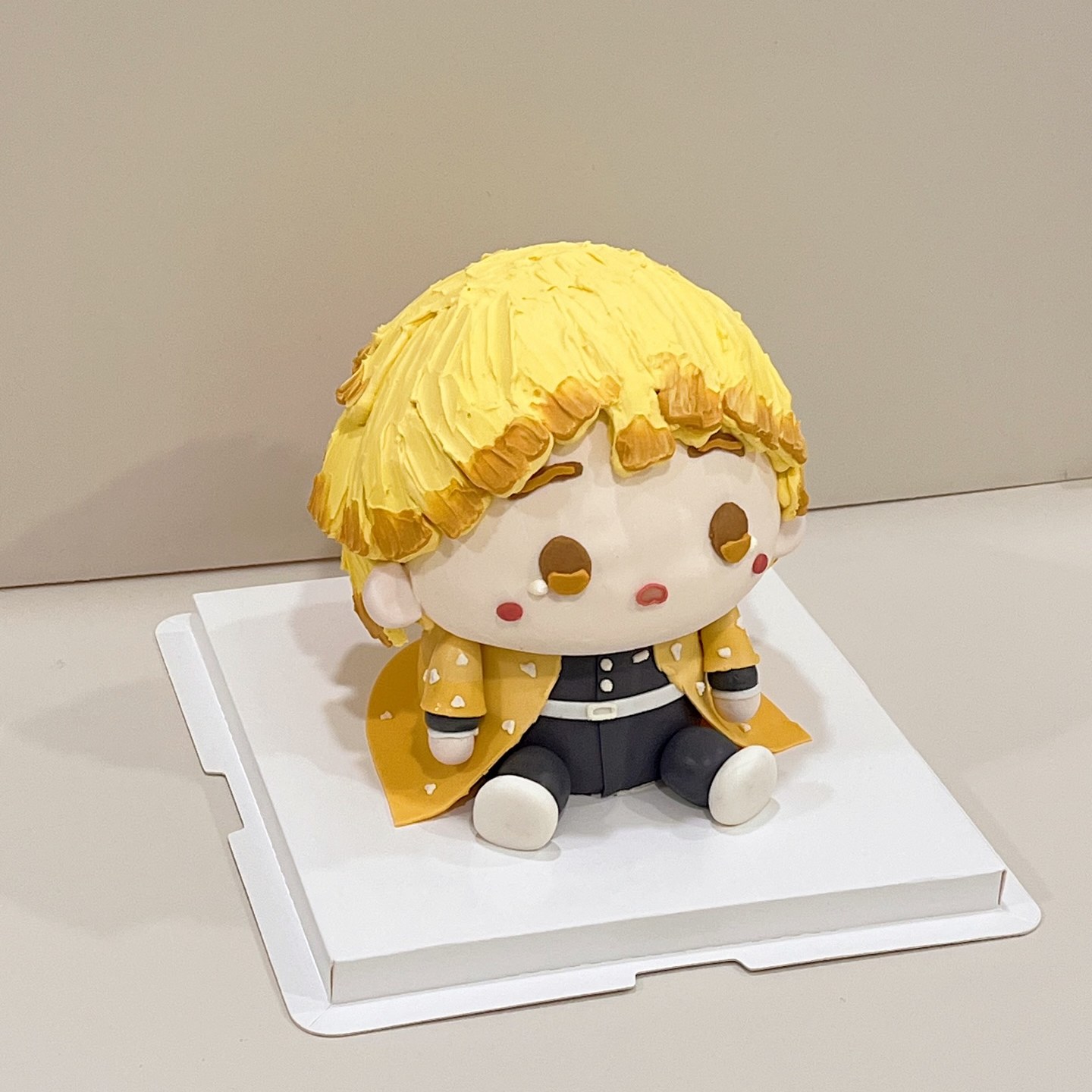 Yellow-haired chibi character cake in a patterned haori and dark uniform