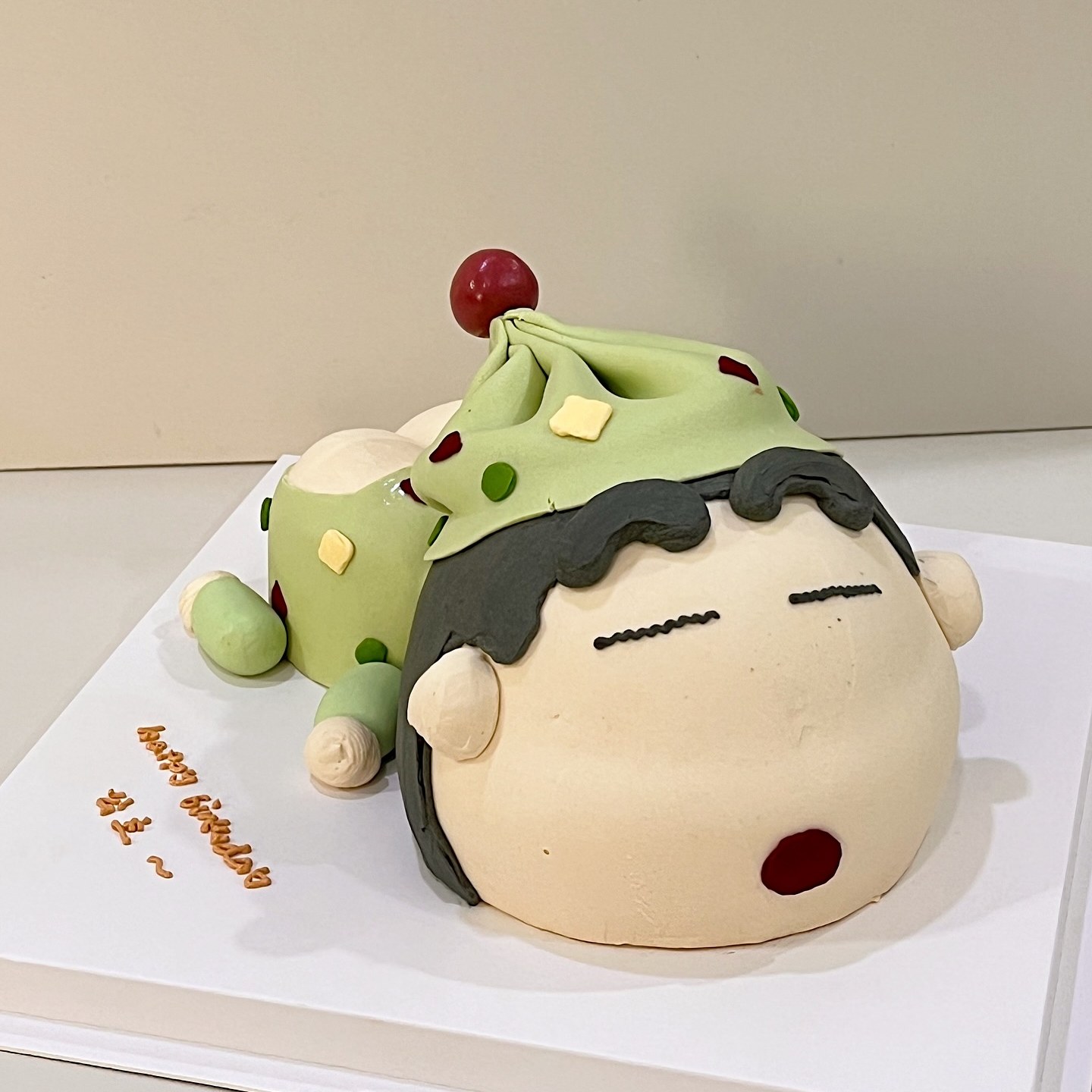 Matcha mochi-styled character cake with a birthday message on the board