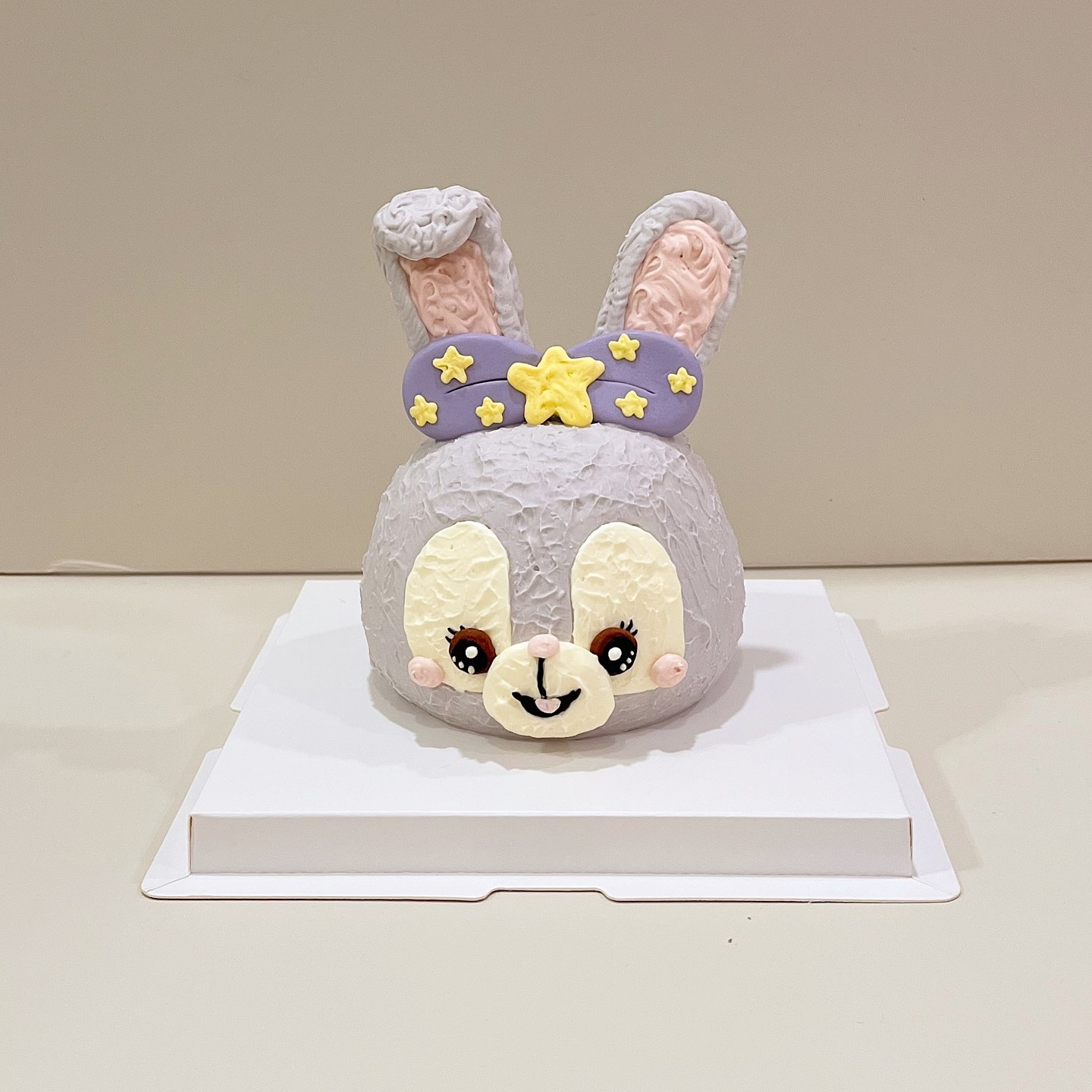 Grey bunny character cake with a starry bow headband