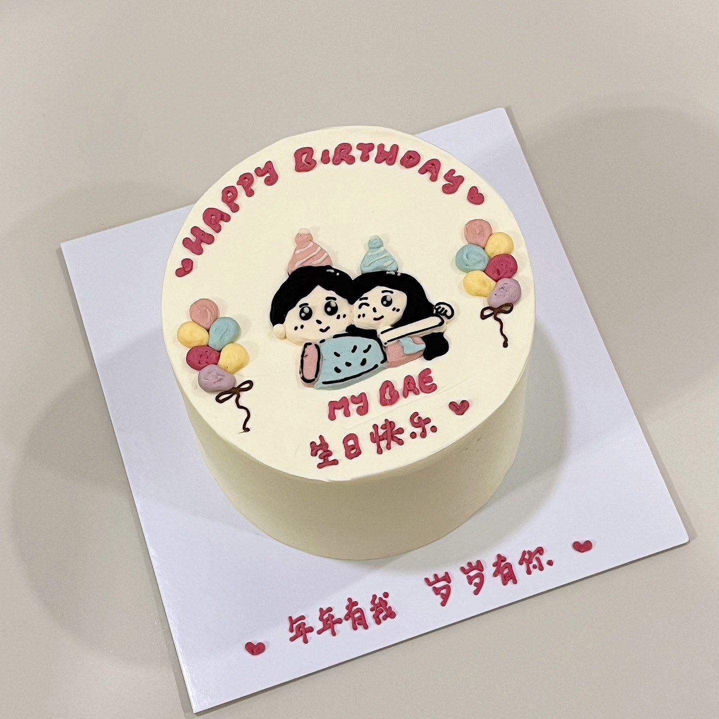 Round cake with a hand-drawn couple portrait, balloons and a birthday message in English and Chinese