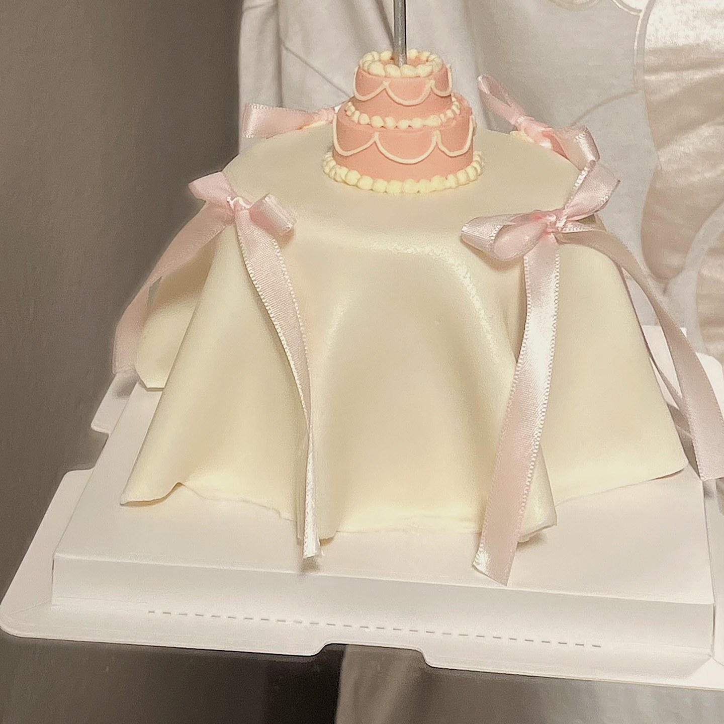 Round cake with a hand-drawn couple portrait and colourful balloon piping, hand-piped in a home kitchen